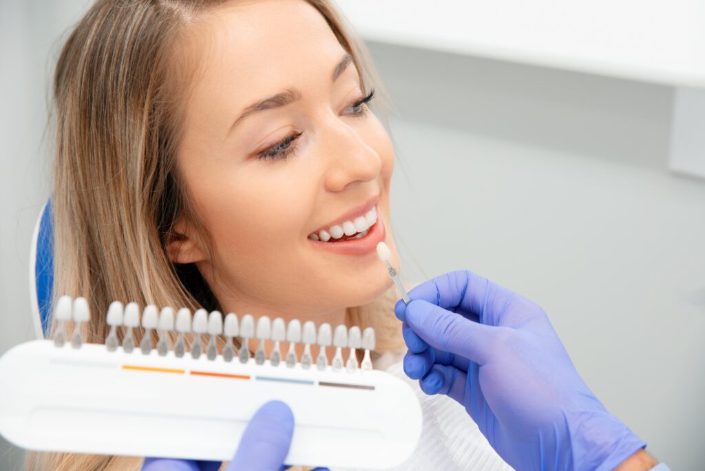 Dentist showing a woman no-prep veneers sample for teeth whitening in Wauwatosa.