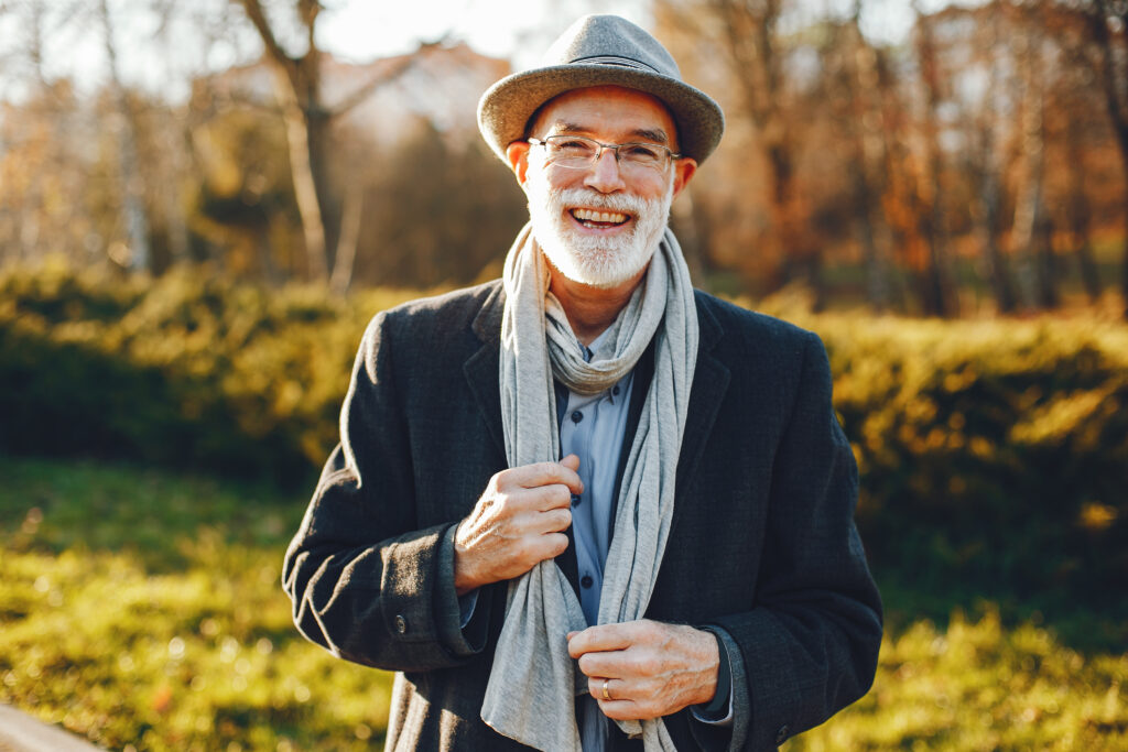 Dental Implant FAQs Wauwatosa older man wearing a scarf and had outside.